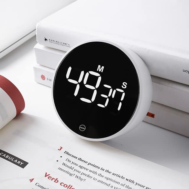 The Timer on a stack of books beside study notes